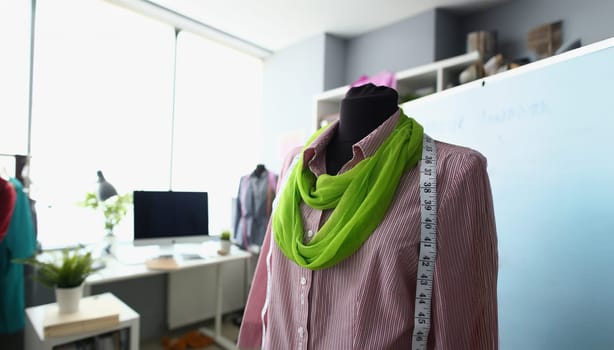 Close-up of mannequin dressed in new collection outfit, combination of colours. Creative workspace in small studio. Successful business, atelier concept