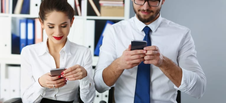 Portrait of group of people hold devices and look at phone screen in office. Read news, mania, send messages non stop, chat addict. Mobile addict concept