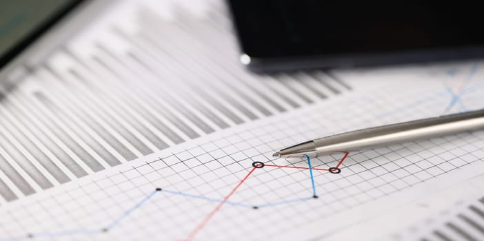 Close-up of business document with some graphic on it, blue and red lines in increase and decrease order. Statistics, business, economy, finance concept