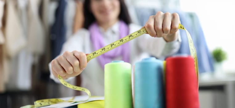 Seamstress stylist keeps centimeter at workplace. Sewing and repairing clothes concept
