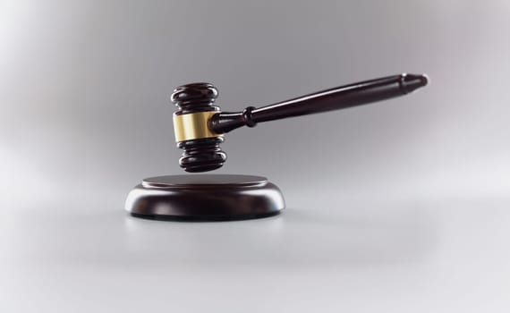 Close-up of judges wooden hammer on soundboard placed grey background. Attorney tool for legal service. Court, law, verdict, legality and justice concept