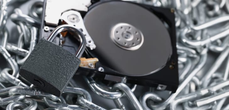 Close-up of data on cd rom secured with chain and padlock equipment, key hole. Keep safe your personal information. Security, protection, safety concept