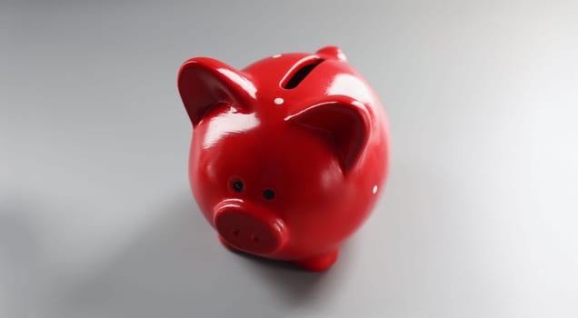 Close-up of bright red piggybank container on grey surface, empty thing to put money. Hole in ceramic animal. Finance, saveup for future, success concept