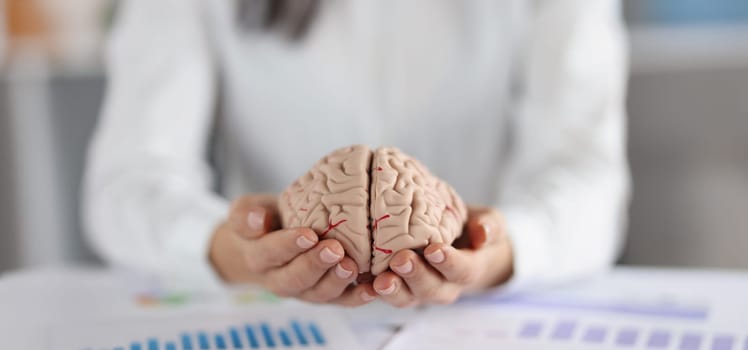 Close-up of woman holding on hands two pieces of human brain, female show fullness on person mind. Ability to think clear, smart, clever, education concept
