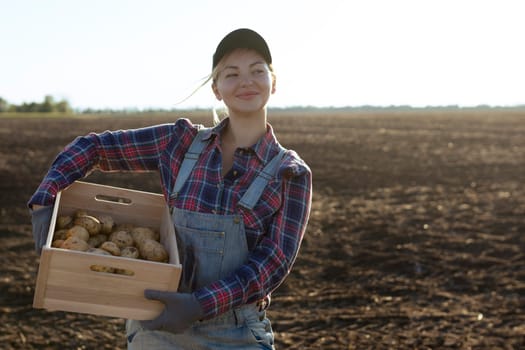 Happy smiling caucasian female potato farmer or gardener. Agriculture - food production, harvest concept.