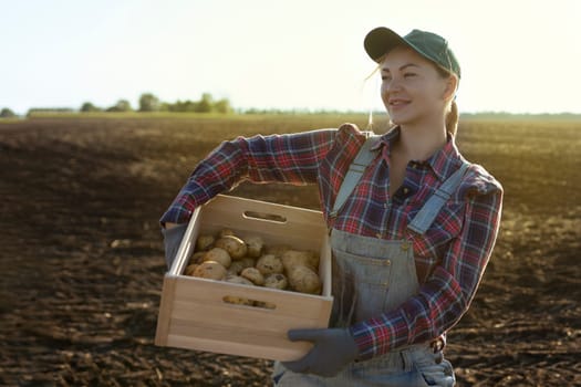 Happy smiling caucasian female potato farmer or gardener. Agriculture - food production, harvest concept.