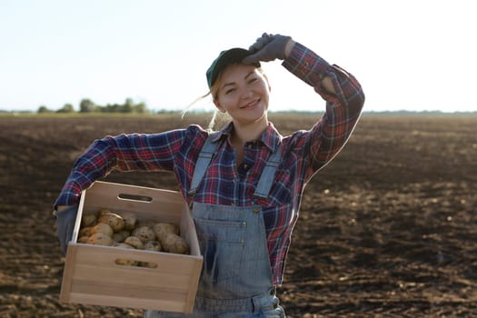 Happy smiling caucasian female potato farmer or gardener. Agriculture - food production, harvest concept.