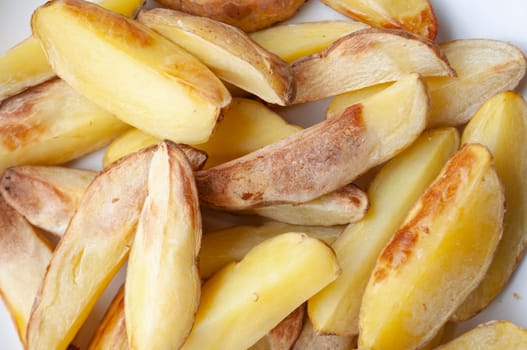 Close up of fresh made fried potato chunks on a piece of baking paper.