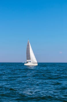 Yacht, white sailboat under head genoa and main sails sailing in an calm open sea. Cruise, vacations, regatta, sport. Gulf of Finland
