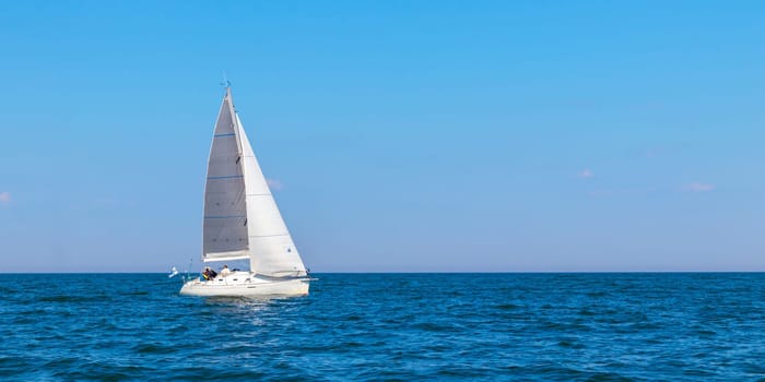 Yacht, white sailboat under head genoa and main sails sailing in an calm open sea. Cruise, vacations, regatta, sport. Gulf of Finland