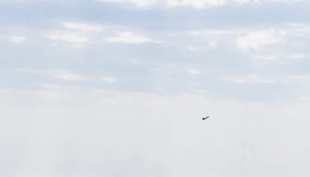 Silhouette of the MIG fighter jet in the cloudy sky
