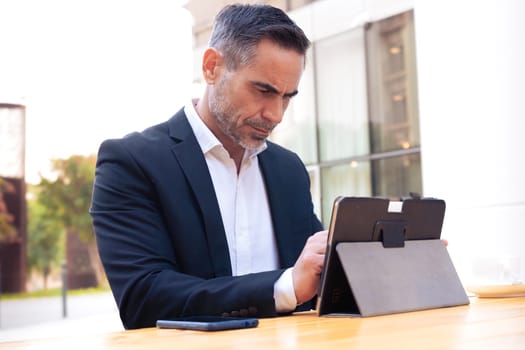 Business on the move: Businessman working on histablet on the street. Man Hands Type On His tablet Outdoors