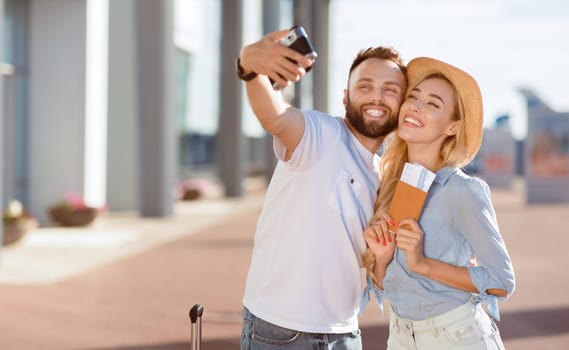 We Love Traveling. Excited beautiful spouses taking selfie by their camera while waiting for boarding near the airport