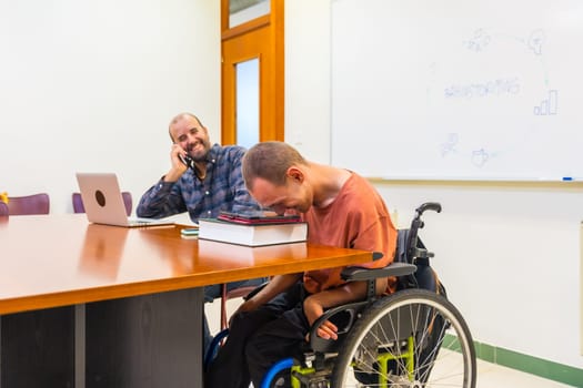 Happy teamwork with a man with disability using tablet in a coworking meeting