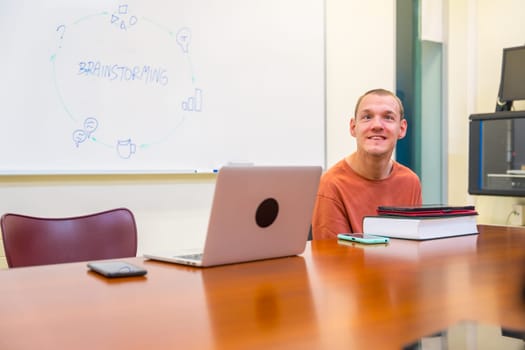 Horizontal photo with copy space of a caucasian disabled man sitting in an university meeting room