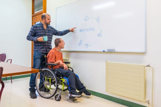 Man with disability and colleague talking during a creative brainstorming in a meeting room