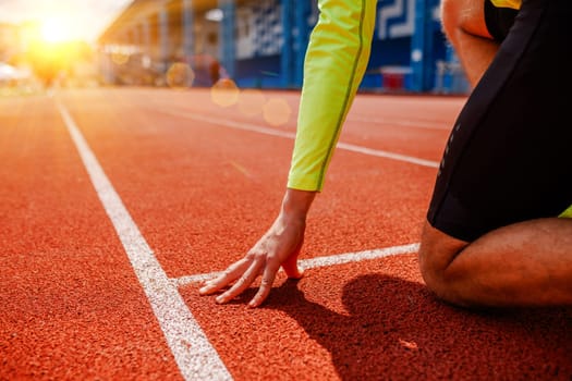 A runner is in the starting position, Rear view of a young female athlete starting the starting line in a race