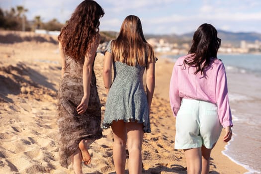 Cheerful multiethnic friends with sunglasses happy on vacation on the beach, looking at the camera.
