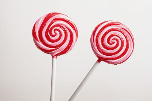 Vibrant spiral lollipop in pink and red, featuring a classic candy swirl pattern.
