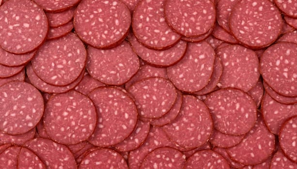 A close-up photograph captures the intricate details of a multitude of perfectly sliced salami rounds. The vibrant red hue of the meat is captivating, while the subtle marbling creates a mesmerizing texture.