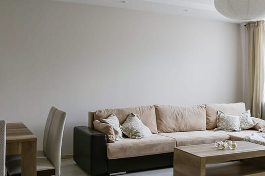 Living room with large sofa, pillows, coffee table, laminate flooring.
