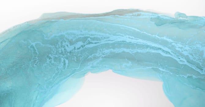 A close-up view of a contemporary abstract watercolor painting, featuring soft, swirling strokes of light blue and white, resembling a wave or a ripple of water.