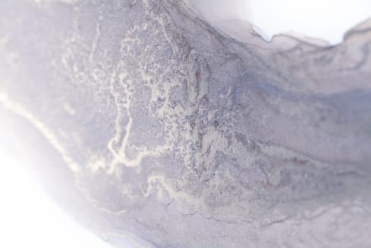 A close-up view of a silver ink swirl against a white background, creating a mesmerizing pattern of abstract shapes and textures.