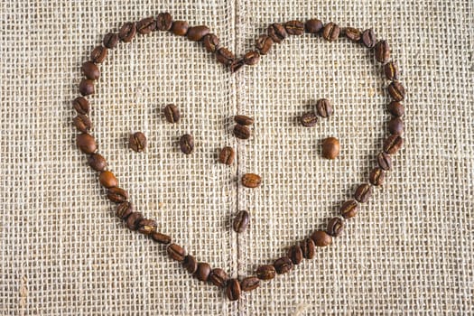 Coffee beans laying down in a heart shape, On a Burlap fabric. Background voor coffee related products.
