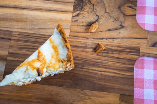 A slice of a fresh home made lemon pie, on a wooden background.