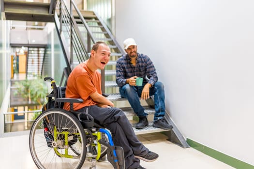 Happy work mates with disability having fun in a work break