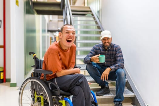 Man with cerebral palsy having fun with teamwork in coworking during a coffee break indoors