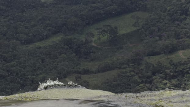 Aerial video of a waterfall from above, showing water plunging into the depths.