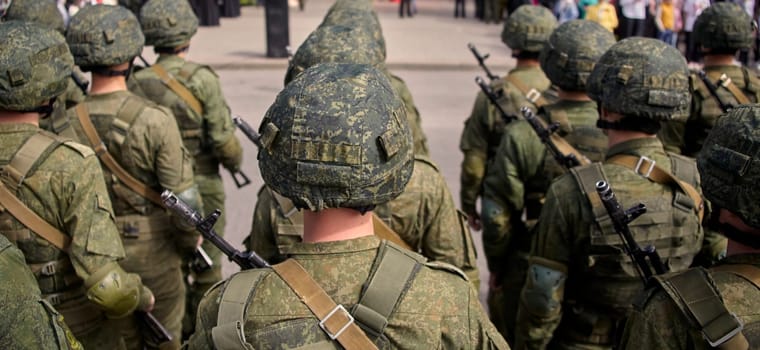 Soldiers in camo uniforms and helmets, armed with rifles, march in a parade displaying military might and discipline. This image captures the essence of military power and patriotism.
