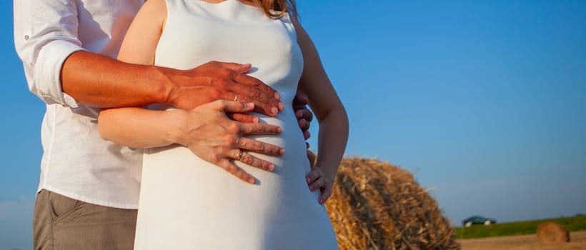 Pregnant belly being cradled by the hands of future parents. Maternity concept isolated on white background. Ideal for baby shower, pregnancy announcement, or Mothers Day celebration.