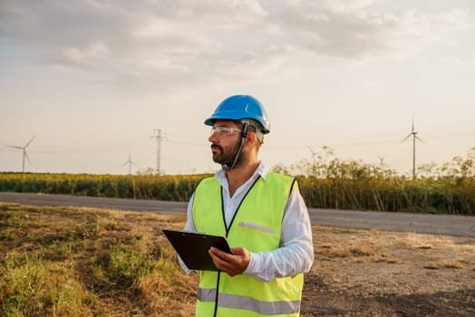 Male engineer cheking wind turbine farm energy generation. Wind turbine engineer at work