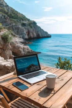 Laptop set up on a wooden table with a breathtaking view of the sea and cliffside