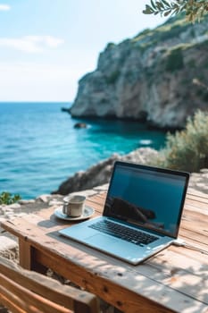 Laptop set up on a wooden table with a breathtaking view of the sea and cliffside