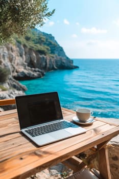 Laptop set up on a wooden table with a breathtaking view of the sea and cliffside