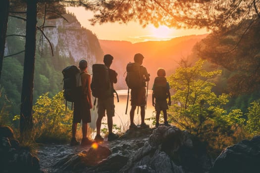 Family of four standing on a rocky outcrop, enjoying a majestic sunset over the mountains
