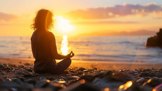 Individual meditating on a pebble beach against a backdrop of a stunning sunset