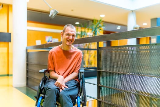 Happy man with cerebral palsy in a modern coworking smiling at camera in the corridor