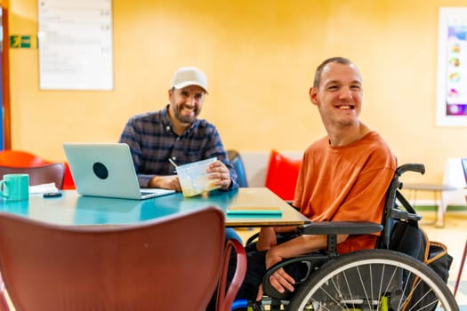 Man with disability and coworker eating together in the dinning room in a modern coworking