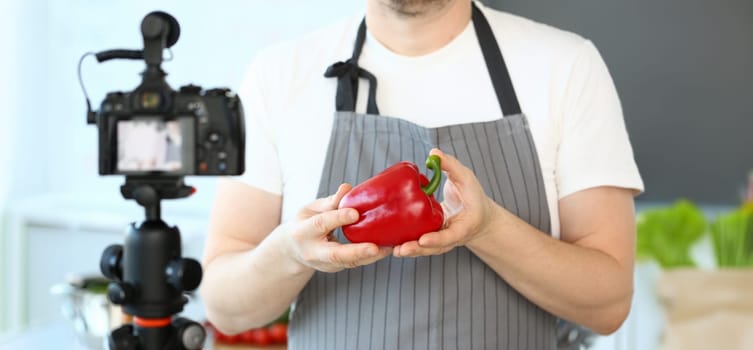 Male Hands Recording Pepper Culinary Recipe Blog. Chef Blogger Showing Red Vegetable Ingredient to Camcorder. Natural Vegetarian Culinary in Kitchen at Home. Organic Food Horizontal Photography