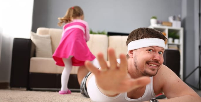 Cute little girl hold her father leg as proof of winning battle game portrait