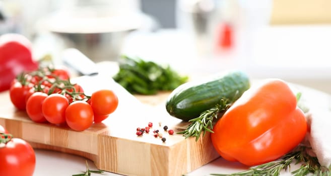 Healthy Organic Vegetables Cutting Board Photo. Small Cherry Tomatoes and Green Cucumber on Wooden Worktop. Aromatic Rosemary and Hot Pepper Spice. Organic Dieting Ingredient Horizontal Photography