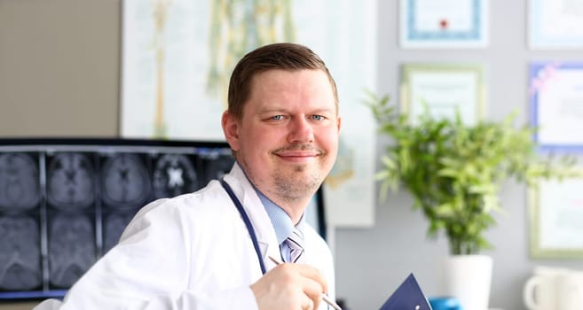 Male doctor in office looking in camera smiling portrait