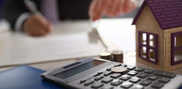 Home Keychain in Real Estate Agent Hand House Rent. Property Loan Sale Concept. House, Calculator. Bank Credit for Residential Purchase. Appertment Sell Items. Mortgage Safety Background