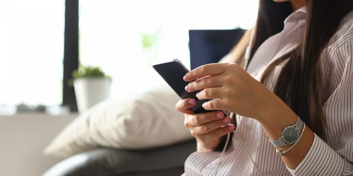 Woman holds smartphone in hand using at home costs about sofa. Verifies internal information its financial advertising freedom makes money level transfer to contractor concept