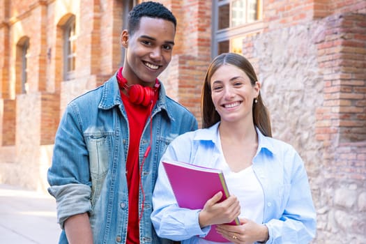 Multicultural students standing on campus with a folder leaving class. Concept of university life