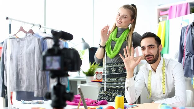 Couple husband and wife portrait wave hand and looks at camera, greet follower and say likes subscription. Family business in sewing and repairing cloth concept.